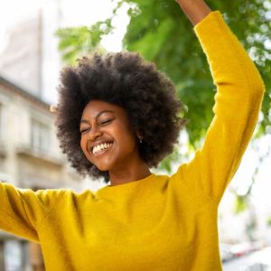 Woman with kinky texture hair dancing and smiling